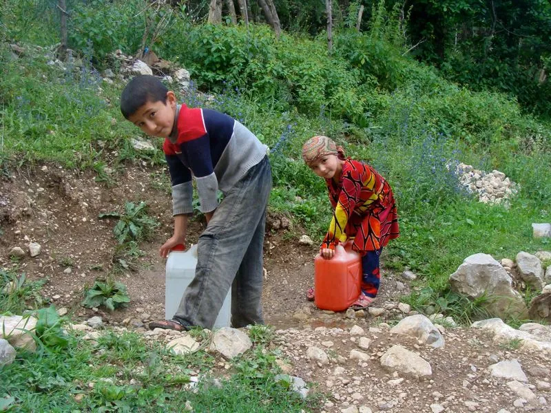 Kinder holen Wasser am Dorfbrunnen