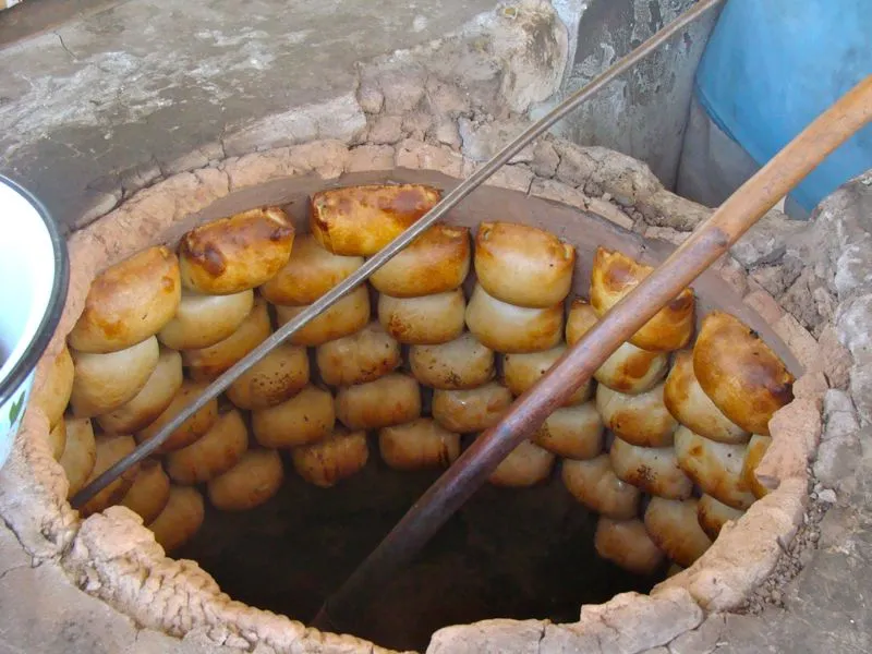 Samsa (Brot mit Fleischfüllung) im typischen Backofen